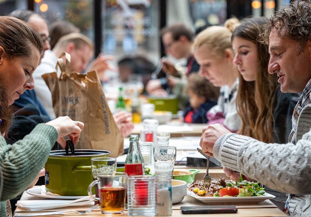 Gasten aan een lange tafel in het restaurant